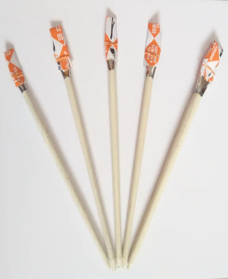 A set of five Annai art brushes fanned out, with long pale wooden handles